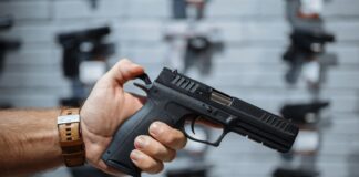 Washington exigirá permiso para comprar armas Una mano de un hombre sostiene una pistola