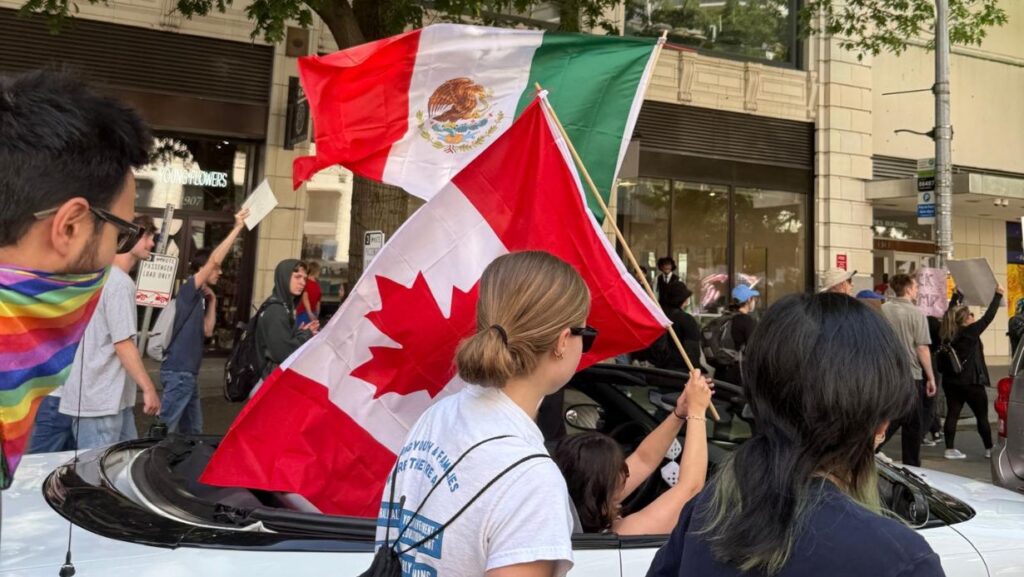 Participantes de la marcha No Kings Seattle ondean banderas de México y Canadá