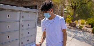 Condado de Pierce llama a jóvenes a actualizar sus firmas para evitar votos rechazados Un hombre joven pone su boleta electoral en el correo