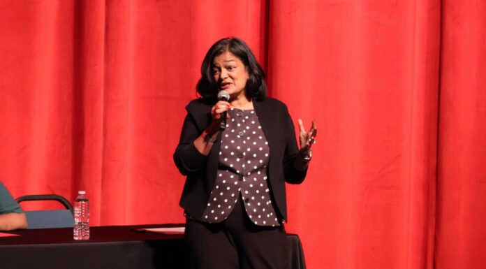 Pramila Jayapal critica al partido republicano de WA y rechaza llamado a “autodeportarse” Pramila Jayapal hablando con micrófono en mano durante el Town Hall en Spokane frente a un telón rojo. © Latino Herald