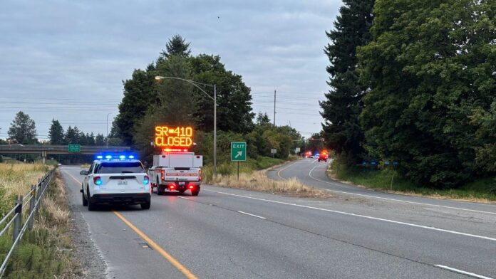 22 GENERAL -3 Vehículos de emergencia bloquean la SR 410 oeste tras un accidente fatal, con un letrero luminoso que indica el cierre total de la vía.