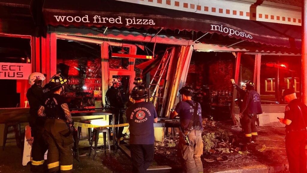 Bomberos de Seattle inspeccionan los daños estructurales tras el impacto del vehículo en Mioposto.