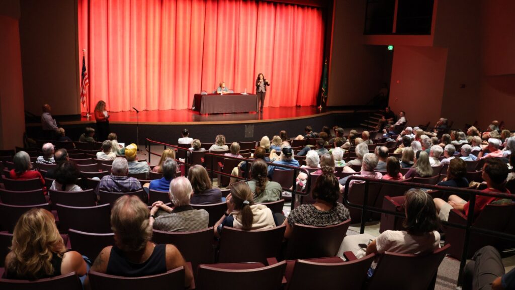 Auditorio bastante concurrido de personas escuchando a Pramila Jayapal y Shasti Conrad durante el evento en el Spokane Falls Community College. © Latino Herald
