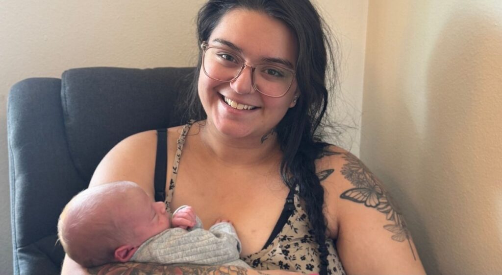 Georgia Vazquez-Rocca, madre, sonríe a la cámara mientras sostiene a su bebé recién nacido, Lucas, que duerme plácidamente.