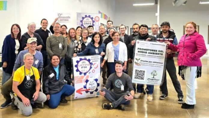Un grupo numeroso de personas sonríe y posa para una foto grupal en un evento de comunidad, sosteniendo letreros que promueven los programas "Promotores del Medio Ambiente" y "Latino Fix-It". Un grupo numeroso de personas sonríe y posa para una foto grupal en un evento de comunidad, sosteniendo letreros que promueven los programas "Promotores del Medio Ambiente" y "Latino Fix-It".
