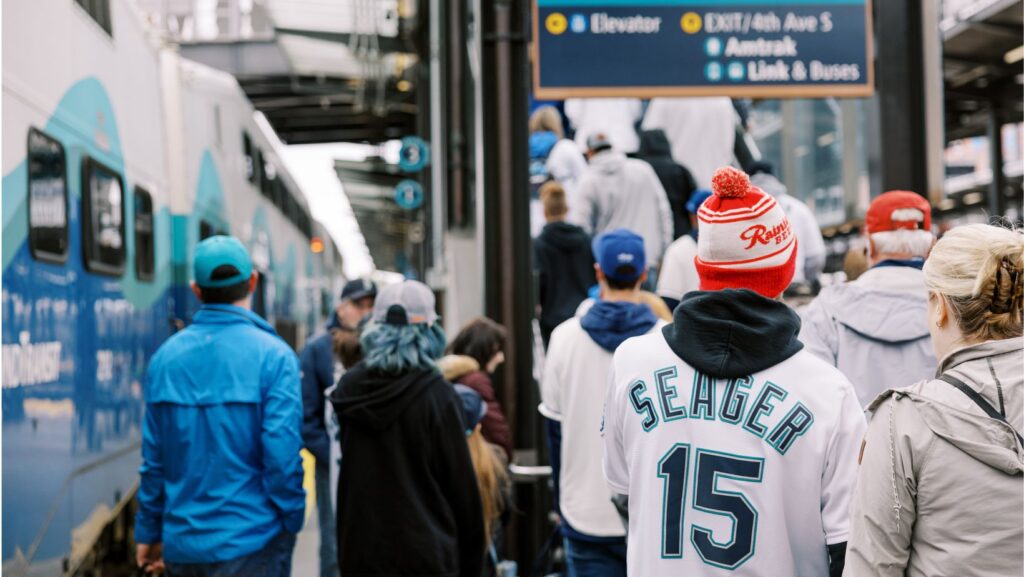 Aficionados con camisetas de los Mariners abordan el tren Sounder en Seattle.