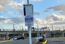 Decenas de autos remolcados cerca de la estación de tren ligero en Lynnwood durante juego de los Mariners etrero de estacionamiento privado con advertencia de remolque en lote frente a la estación de tren ligero Lynnwood City Center.