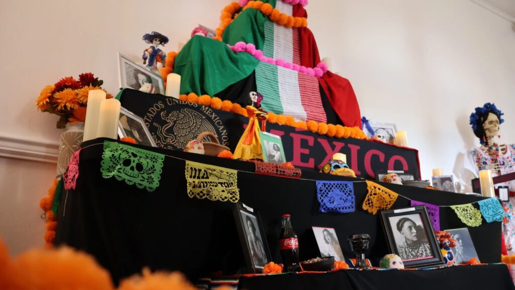 Altar del Día de Muertos del Consulado de México en Seattle, decorado con flores de cempasúchil, papel picado y fotografías de mujeres artistas mexicanas, como parte del homenaje cultural organizado junto a Seattle Theatre Group.