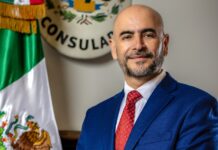 Víctor Hugo López: el nuevo Cónsul General de México en Seattle y la visión que trae al PNW Víctor Hugo López, Cónsul de México en Seattle, de pie en la sede consular con la bandera de México al fondo.