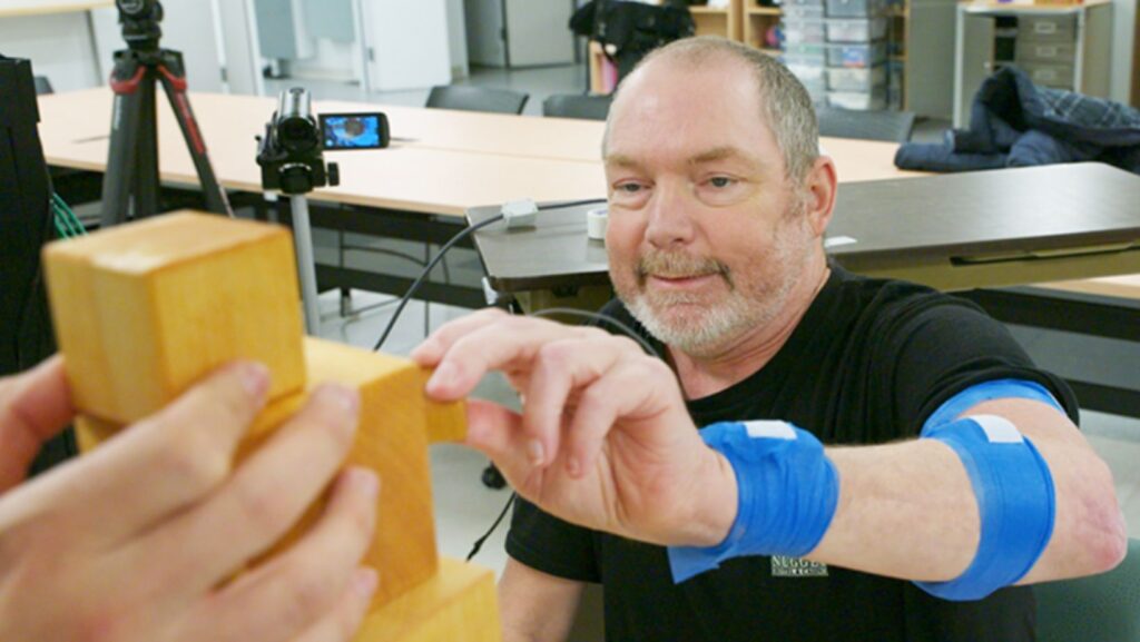 Matt Kidd realiza ejercicios de rehabilitación con la mano durante una sesión de terapia tras un derrame cerebral como parte de un estudio clínico de UW Medicine. Foto: Tim Griffis / UW Medicine. Material propiedad de UW Medicine.