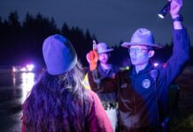 Nueva ley en Washington busca reducir retrasos en pruebas de alcoholemia Una mujer realiza una prueba ocular de sobriedad mientras un oficial sostiene una linterna en un control policial nocturno.