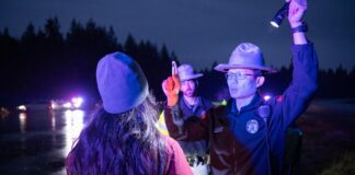 Nueva ley en Washington busca reducir retrasos en pruebas de alcoholemia Una mujer realiza una prueba ocular de sobriedad mientras un oficial sostiene una linterna en un control policial nocturno.