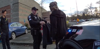 Robo en Target de Redmond termina con arresto y apoyo humanitario Foto: Agentes de Redmond le entregan a un hombre en situación de calle una chamarra - Cortesía de la policía de Redmond