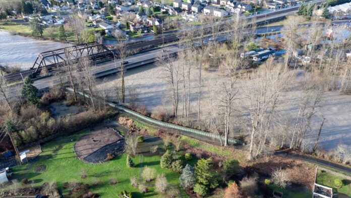 Vista aérea del White River en Auburn, WA, tras alcanzar la fase 4 de inundación, con el caudal elevado cerca de zonas urbanas y vías de transporte.