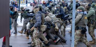 Autoridades federales alistan despliegue de 1.500 soldados en Minnesota Agentes de ICE repelen una manifestación frente al edificio Bishop Henry Whipple, en St. Paul, Minnesota, en enero de 2026. En este complejo operan las cortes migratorias a las que ICE traslada a personas detenidas - Imagen capturada por Colton de Blue G Productions.
