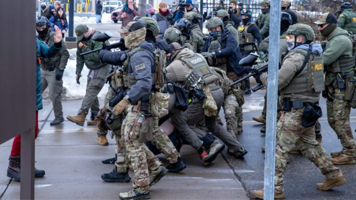 Minnesota ICE protests Agentes de ICE repelen una manifestación frente al edificio Bishop Henry Whipple, en St. Paul, Minnesota, en enero de 2026. En este complejo operan las cortes migratorias a las que ICE traslada a personas detenidas - Imagen capturada por Colton de Blue G Productions.