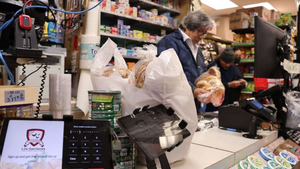 Clientes pagan sus compras en el área de cajas del supermercado Los Gavilanes en Everett.