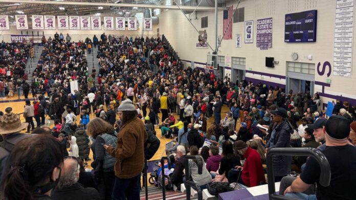 Multitud reunida dentro del gimnasio de la preparatoria Garfield en Seattle durante la marcha del Día de Martin Luther King Jr., con cientos de asistentes ocupando las gradas y la cancha antes de iniciar la caminata hacia el centro de la ciudad.