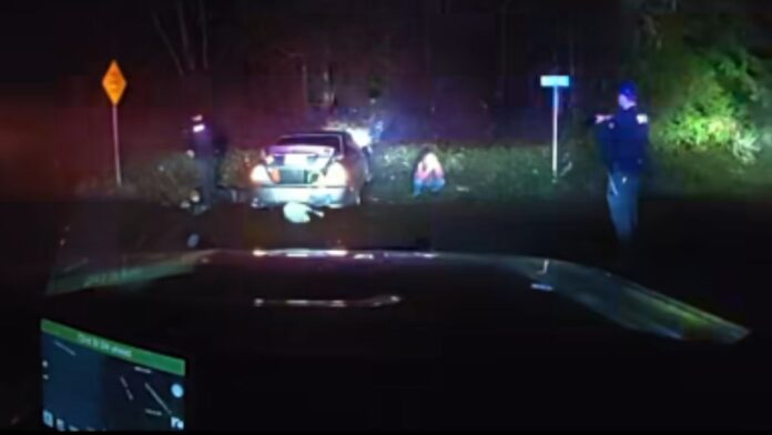 Foto: Oficiales acercándose al vehículo luego de que este chocara con el terraplén - Cortesía de la oficina del sheriff del condado de Pierce