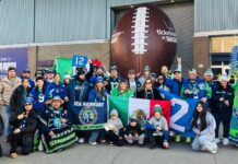 Sea Hawkers Latin America celebra el Super Bowl con fiesta en Burien Miembros del club Sea Hawkers Latin America posan frente al estadio de los Seattle Seahawks con banderas de México y el banner oficial del club