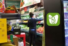 ¿Sabías que el IMSS permite afiliación de trabajadores independientes desde Estados Unidos? Trabajadora latina organizando frutas y verduras en una tienda comunitaria en Washington, un ejemplo de mexicanas y mexicanos que pueden acceder al programa de incorporación del IMSS desde Estados Unidos