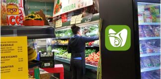 ¿Sabías que el IMSS permite afiliación de trabajadores independientes desde Estados Unidos? Trabajadora latina organizando frutas y verduras en una tienda comunitaria en Washington, un ejemplo de mexicanas y mexicanos que pueden acceder al programa de incorporación del IMSS desde Estados Unidos