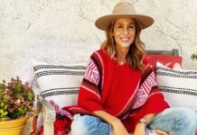 Sylvia Villagrán: la voz latina detrás de grandes eventos internacionales Sylvia Villagrán sentada al aire libre con sombrero y poncho rojo, sonriendo en un entorno relajado.