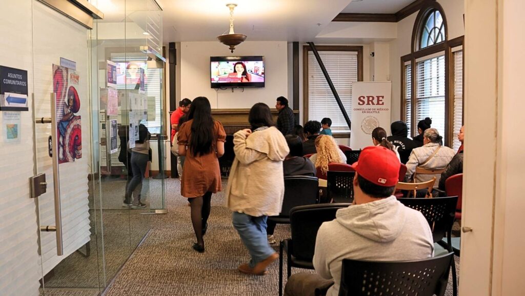 Personas mexicanas reunidas en la sala de espera del Consulado de México en Seattle, buscando orientación sobre trámites y programas como el de incorporación de trabajadores independientes del IMSS.