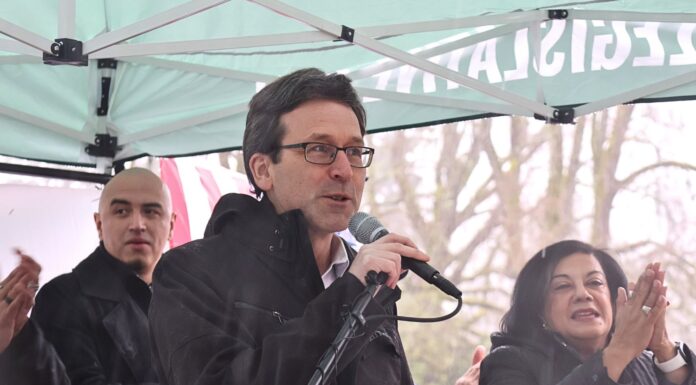 Debate sobre el «impuesto a los ricos» toma un giro inesperado tras la postura de Ferguson El gobernador Bob Ferguson pronuncia un discurso en las escalinatas del Capitolio durante el Día Legislativo Latino en Olympia, acompañado por la representante Lilian Ortiz-Self. 02/02/26. Foto: Latino Herald TM.