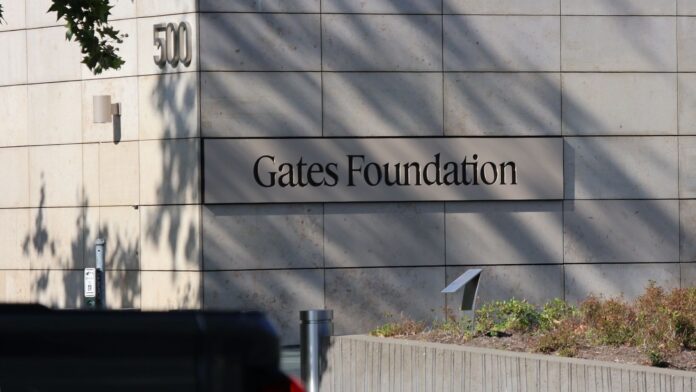 Fundación Gates Fachada del edificio de la Fundación Gates con el letrero visible en la pared exterior y el número 500 en la esquina, rodeado de vegetación en Seattle.
