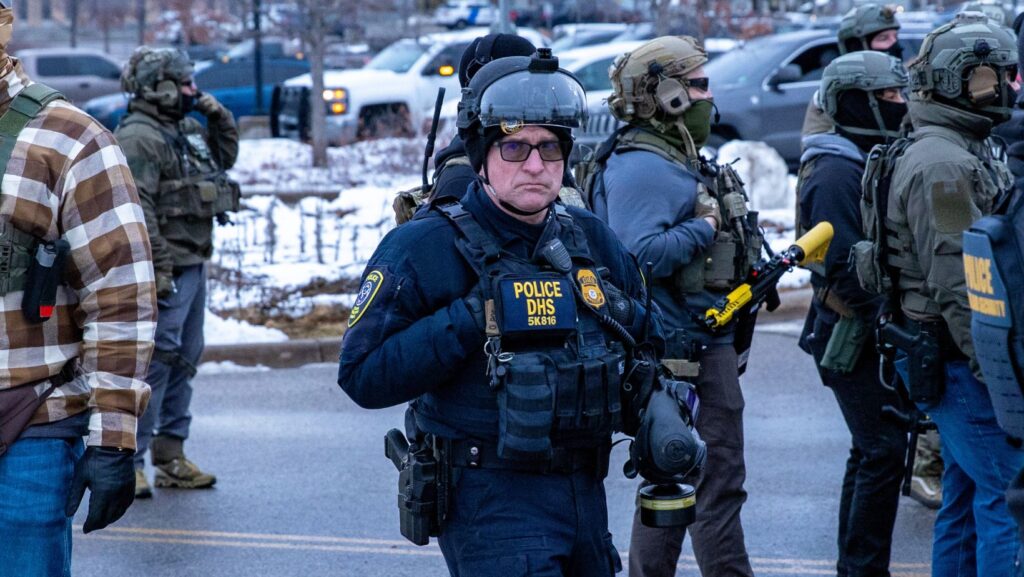Agentes de inmigración observan una protesta frente a la sede de las cortes migratorias en St. Paul, Minnesota, en enero de 2026 - Imagen capturada por Colton de Blue G Productions.