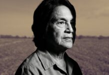 “La traición de Cesar Chavez”: Latino Civic Alliance fija postura ante denuncias recientes Retrato en blanco y negro de Dolores Huerta mirando hacia el horizonte, con un paisaje agrícola desenfocado al fondo.