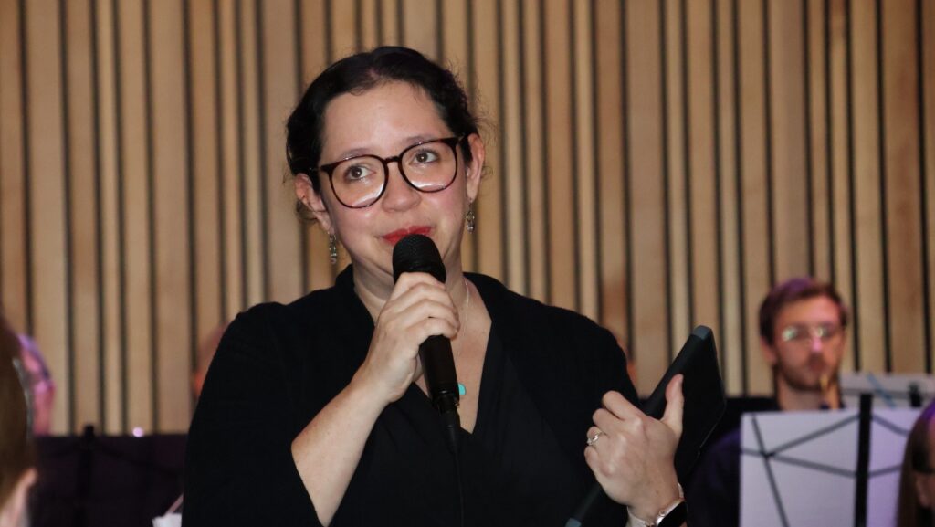 La compositora Shanti Seidel Molina dirige unas palabras al público durante su participación en el concierto del Día de la Mujer en el National Nordic Museum. Foto: Latino Herald™