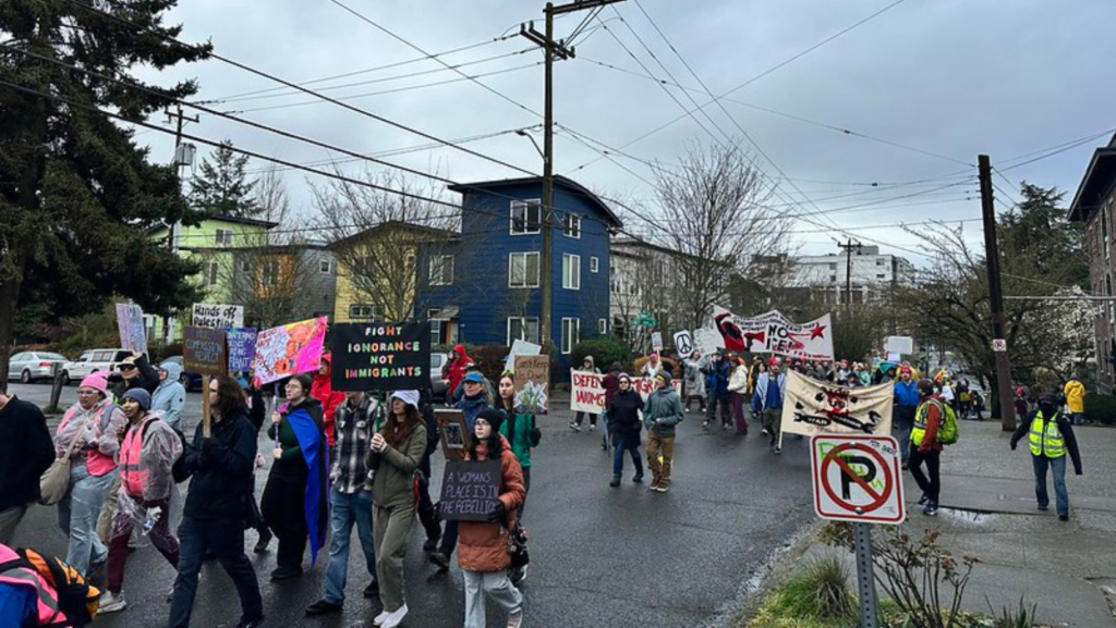 Cientos de personas marchan por una calle de Seattle durante la Marcha de Mujeres del 8 de marzo, portando pancartas en defensa de los derechos de las mujeres y de los inmigrantes mientras avanzan hacia el Parque Cal Anderson.