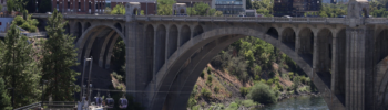 Puente Monroe Street en Spokane, Washington, con su estructura de arco sobre el río Spokane y edificios del centro al fondo en un día soleado