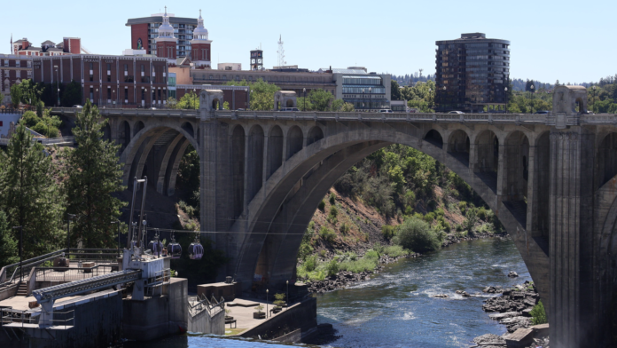Puente Monroe Street en Spokane, Washington, con su estructura de arco sobre el río Spokane y edificios del centro al fondo en un día soleado