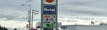 Señal de una gasolinera 76 en Edmonds, Washington, mostrando precios superiores a 5 dólares por galón para gasolina regular y diésel en la carretera 99.