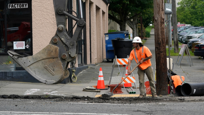 Un trabajador excava en una zanja donde se están reemplazando tuberías en el centro de Tacoma, Washington. (Foto AP/Ted S. Warren)