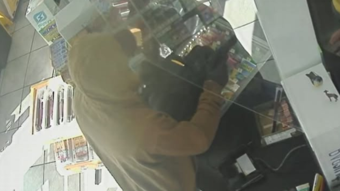 Robo Imagen de cámara de seguridad muestra a un sospechoso con sudadera clara dentro de una gasolinera durante un presunto robo a mano armada en Centralia.