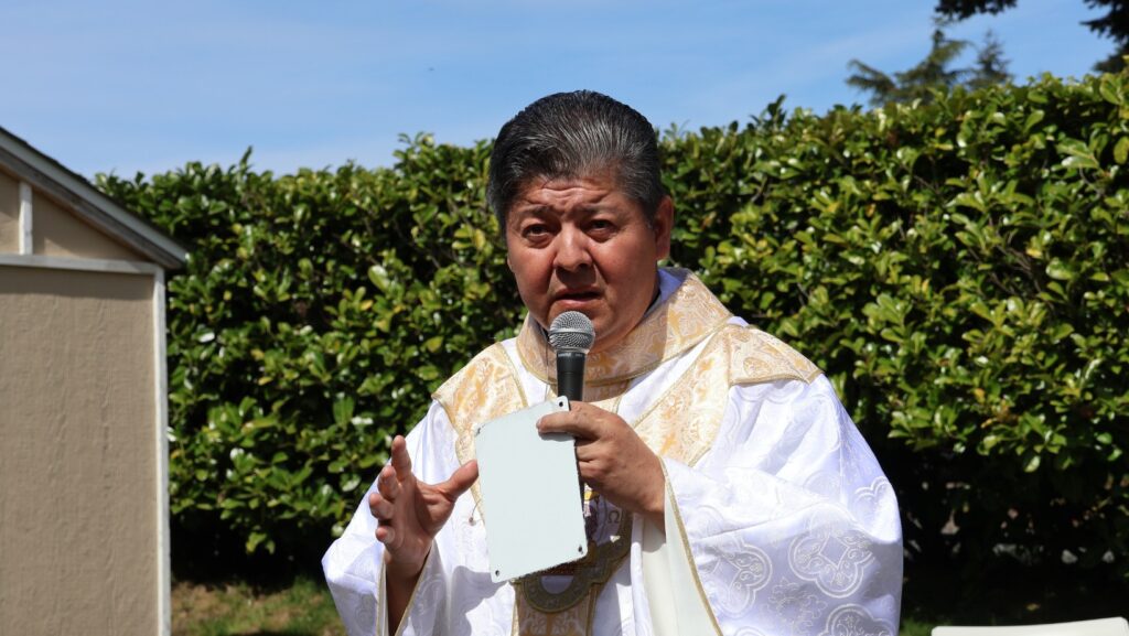 Sacerdote bendice el jardín comunitario de Mercy House durante ceremonia en Mountlake Terrace