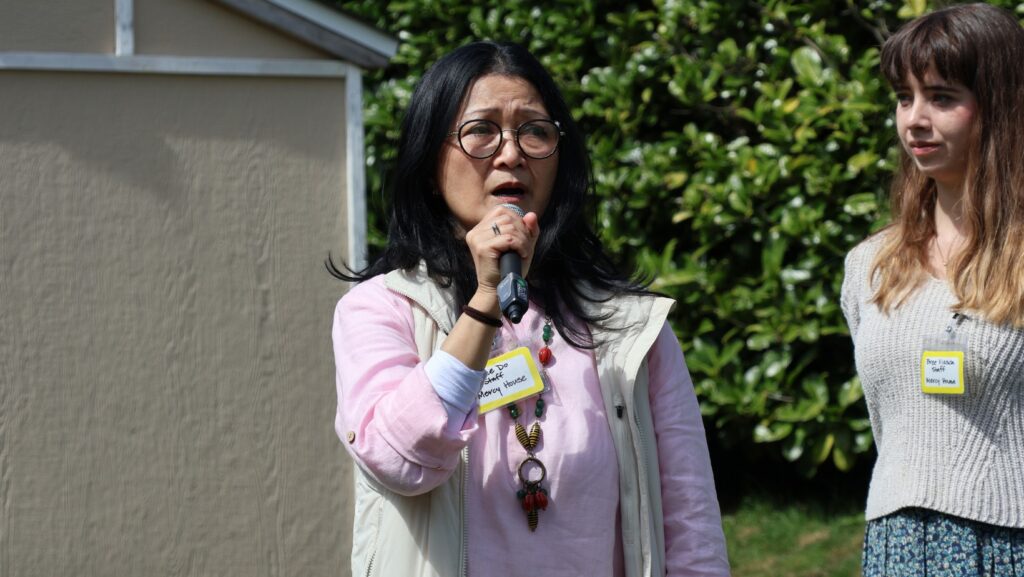 Aimee Do de Mercy House habla durante la inauguración del jardín comunitario en Mountlake Terrace