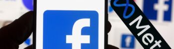 Teléfono celular con el logotipo de Facebook junto al logotipo de Meta.