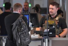 Lo que deben saber los viajeros de WA sobre agentes de inmigración en aeropuertos Un agente del ICE atiende un puesto de control de TSA en el Aeropuerto Internacional de Pittsburgh, en Imperial, Pensilvania, el jueves 26 de marzo de 2026. (Foto de AP/Gene J. Puskar)