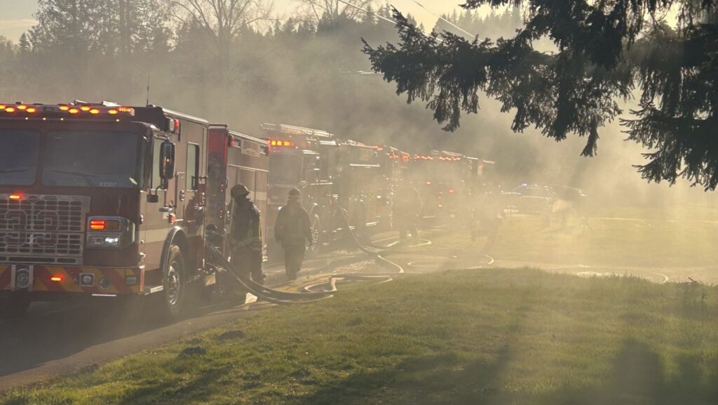 Varias unidades de bomberos del Cuerpo Regional de Snohomish trabajan entre humo denso mientras combaten un incendio en un tráiler en Woodinville.