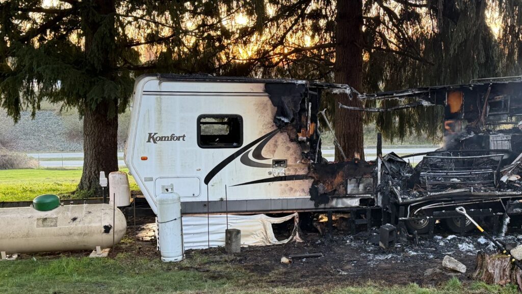 Un tráiler quedó parcialmente calcinado tras un incendio en Woodinville, con daños severos en uno de sus costados y un tanque de propano visible cerca de la estructura.