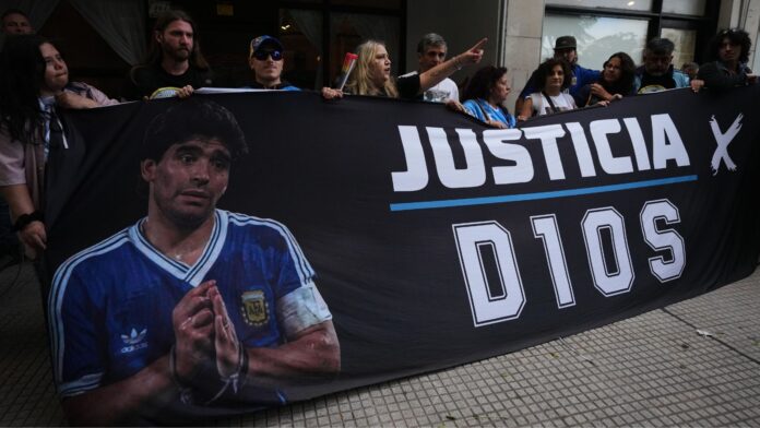 Fanáticos de Maradona se concentran frente al juzgado el primer día del juicio contra su equipo médico por presunto homicidio por negligencia en San Isidro, Argentina, el martes 14 de abril de 2026. (Foto AP/Rodrigo Abd)
