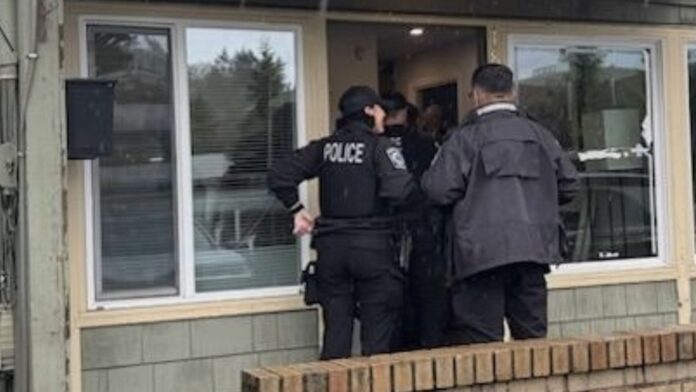 Agentes de la policía de Bothell ingresan a un establecimiento de masajes durante un operativo.