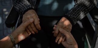 El cuidado familiar en WA alcanza un valor de 25 mil millones de dólares al año Una mujer sostiene las manos de su madre anciana. (Foto de AP/Bernat Armangue)