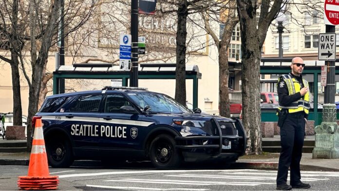 Oficial de la policía de Seattle dirigiendo el tráfico en el Distrito Internacional Chinatown — Imagen: Latino Herald ™