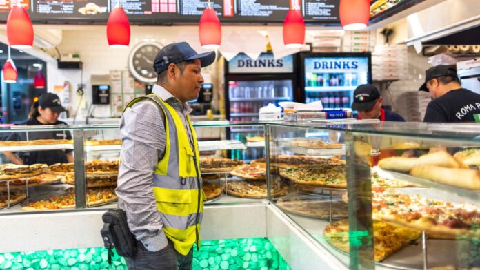Sergio Solano, inmigrante mexicano, espera su cena en una pizzería tras terminar su jornada laboral en Nueva York. Foto de AP/Eduardo Muñoz Álvarez)